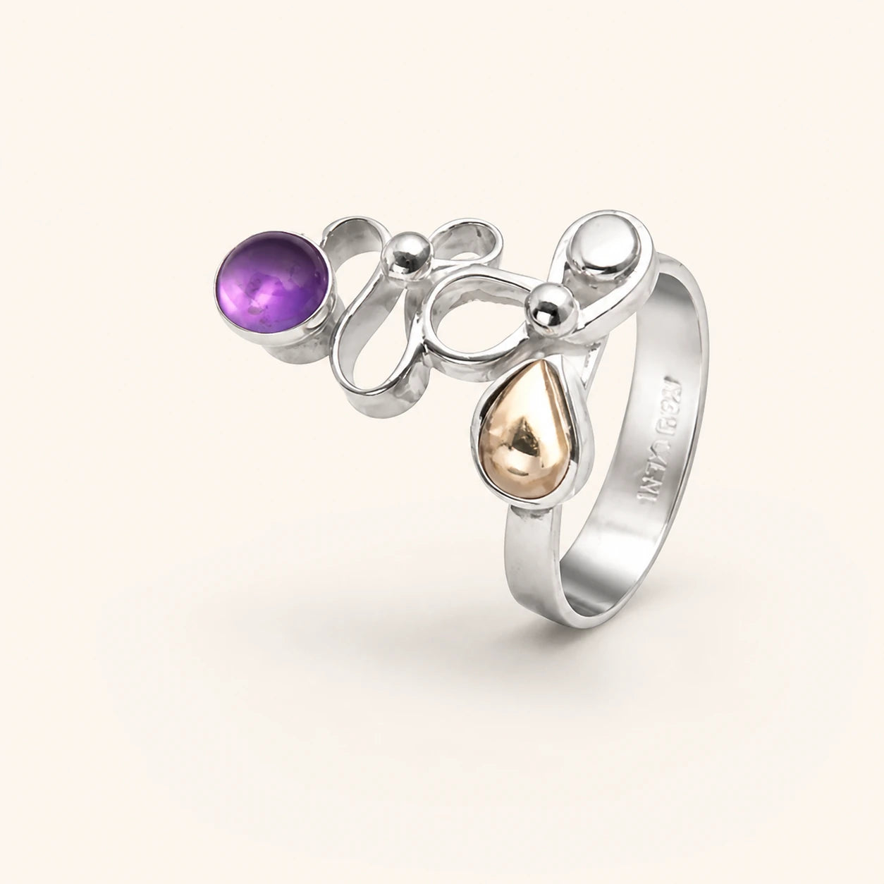 Sculptural silver ring with purple and warm gold-colored stones