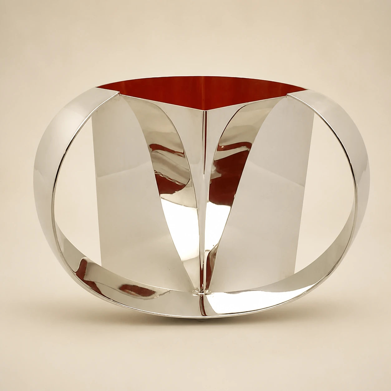 Sculptural polished silver washing cup with a warm red interior