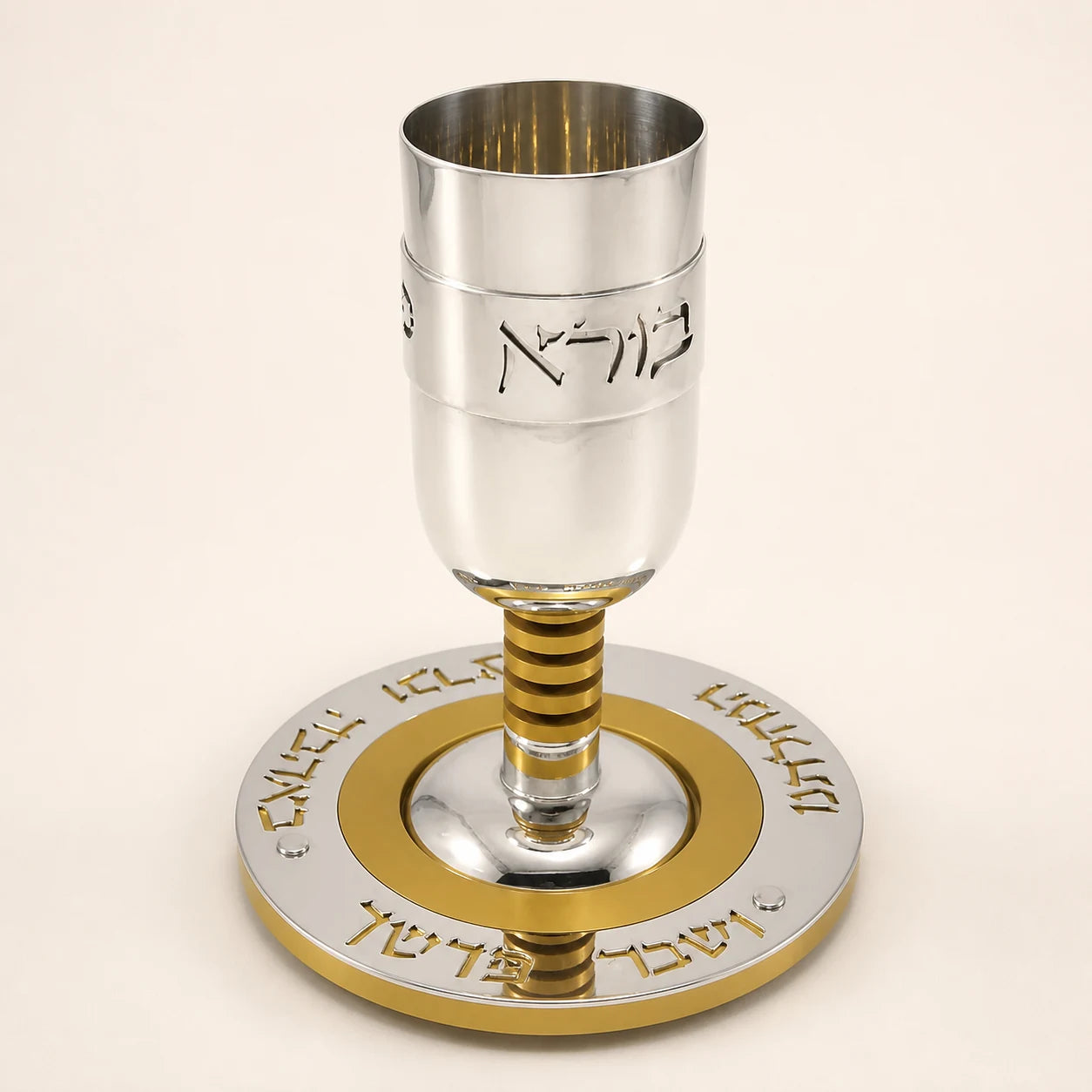 Silver Kiddush cup with gold-colored details and matching circular plate